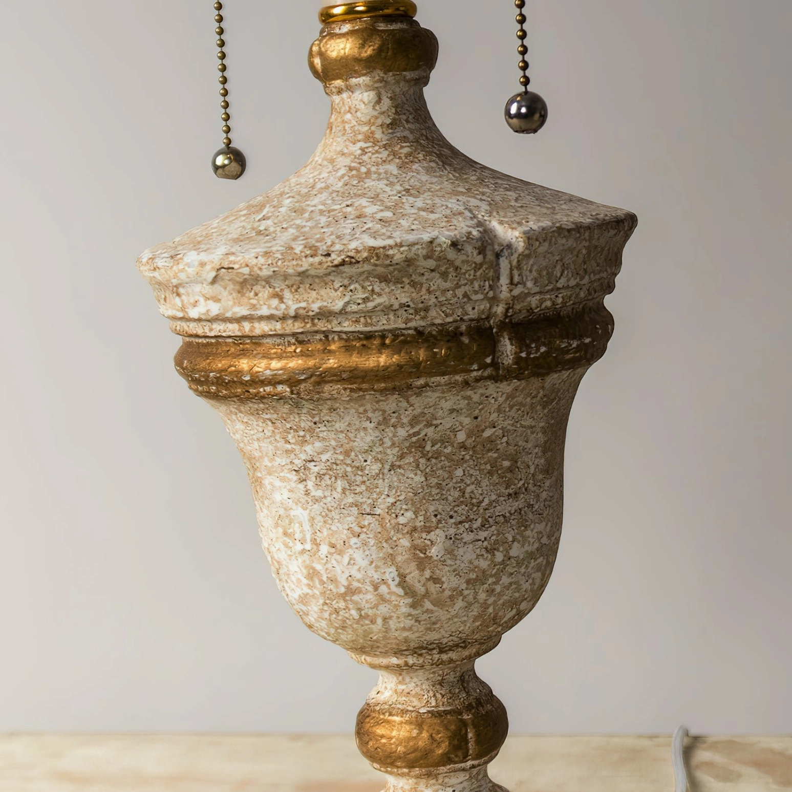 Close-up detail of Beatrix lamp base showing ornate neoclassical carving, gold-trimmed accents, and pull chain hardware
