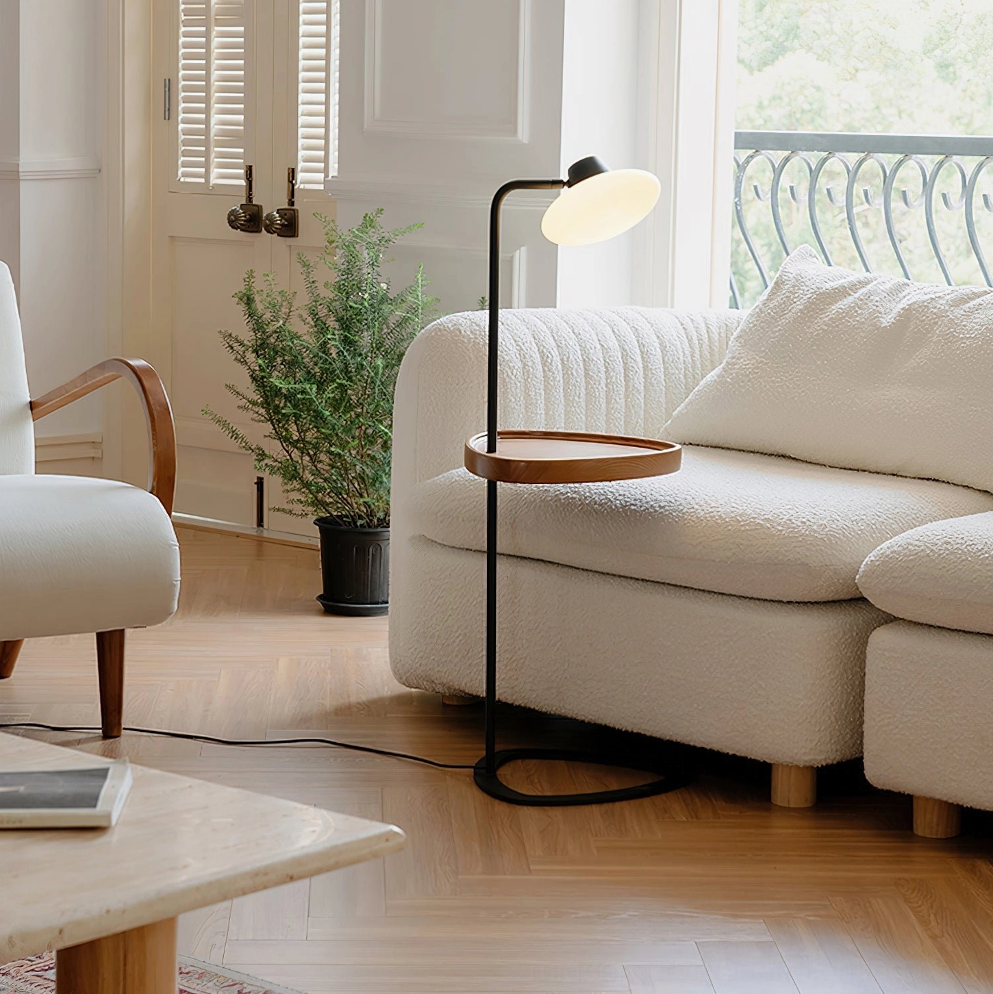Beatrix floor lamp with warm wood tray in sunlit living room, sofa and potted plant, Scandinavian interior design