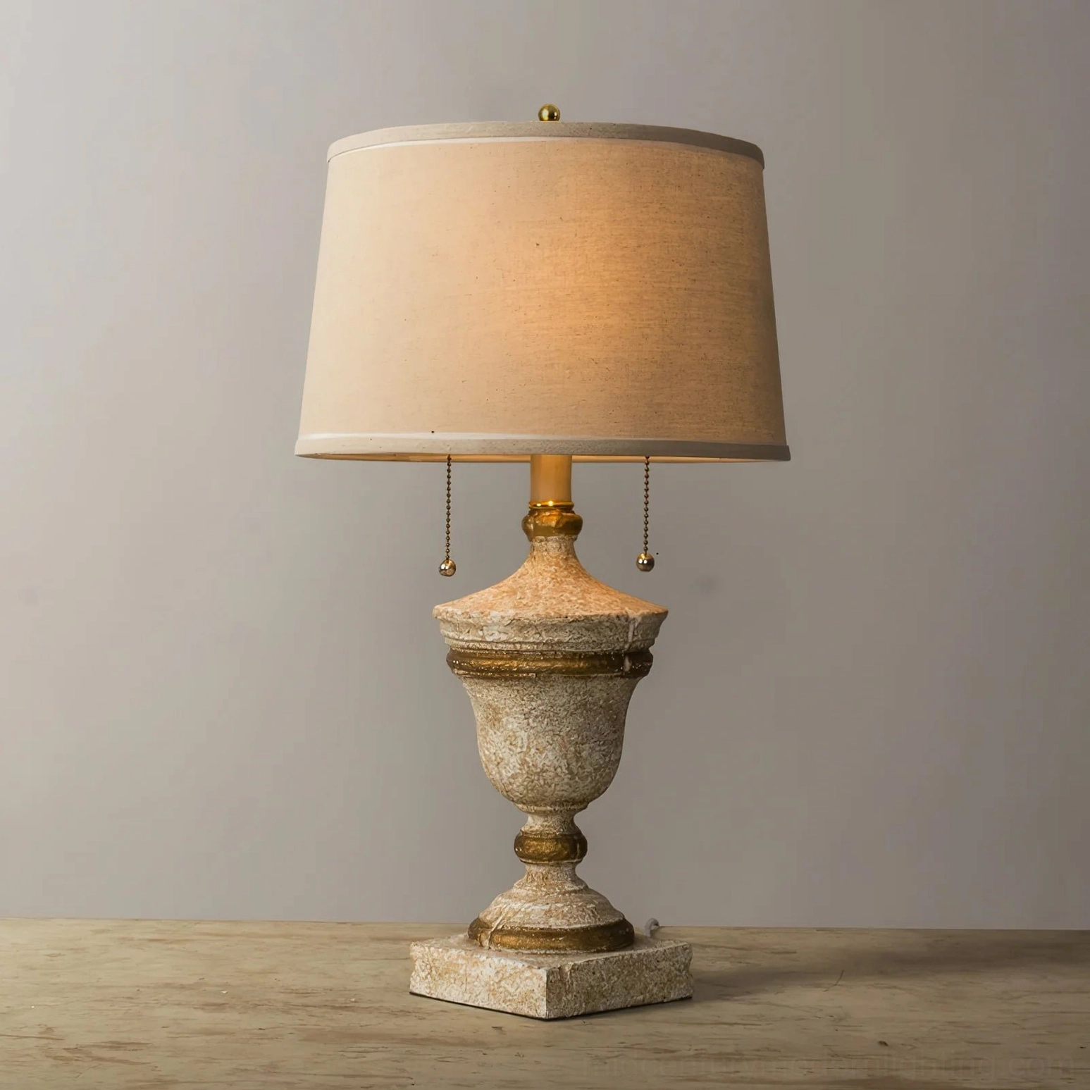 Beatrix neoclassical table lamp with dual pull chains and natural linen shade - three-quarter angle lifestyle shot