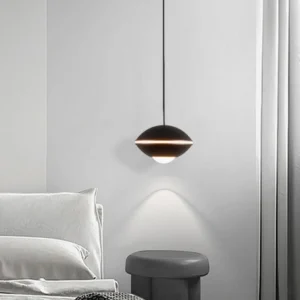 Modern matte black disc pendant light in contemporary bedroom setting, warm downlighting