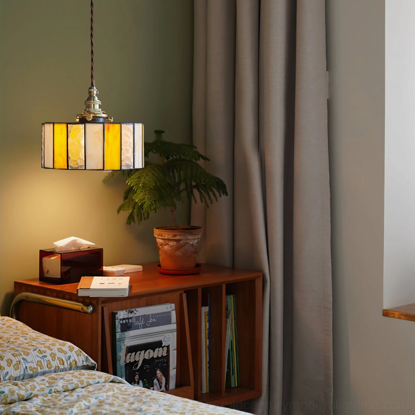 Vintage amber stained glass drum pendant light in bedroom with wooden side table and bed, showcasing mid-century modern aesthetic