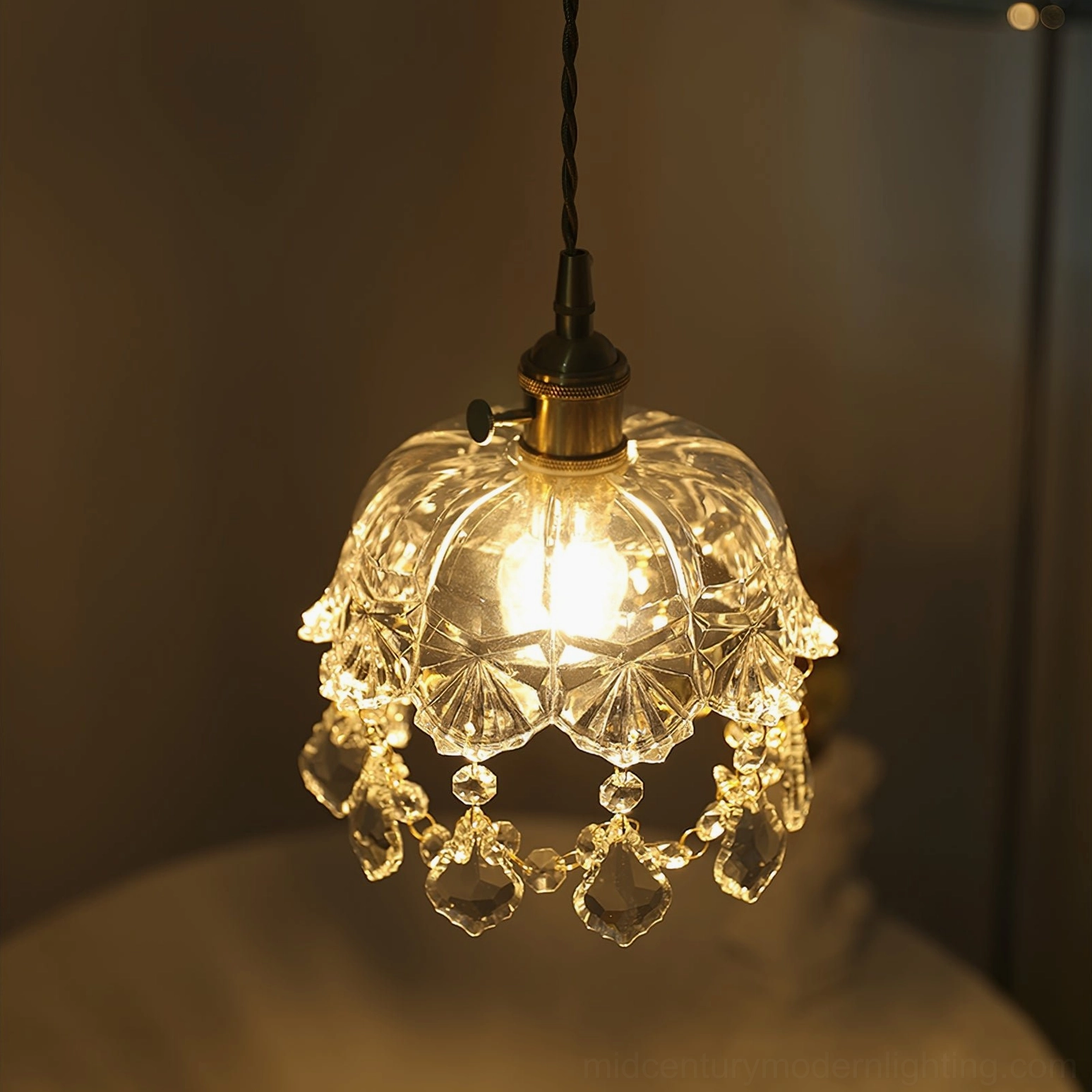 Glowing crystal glass jewel pendant in bedroom interior, warm ambient lighting, brass fixture