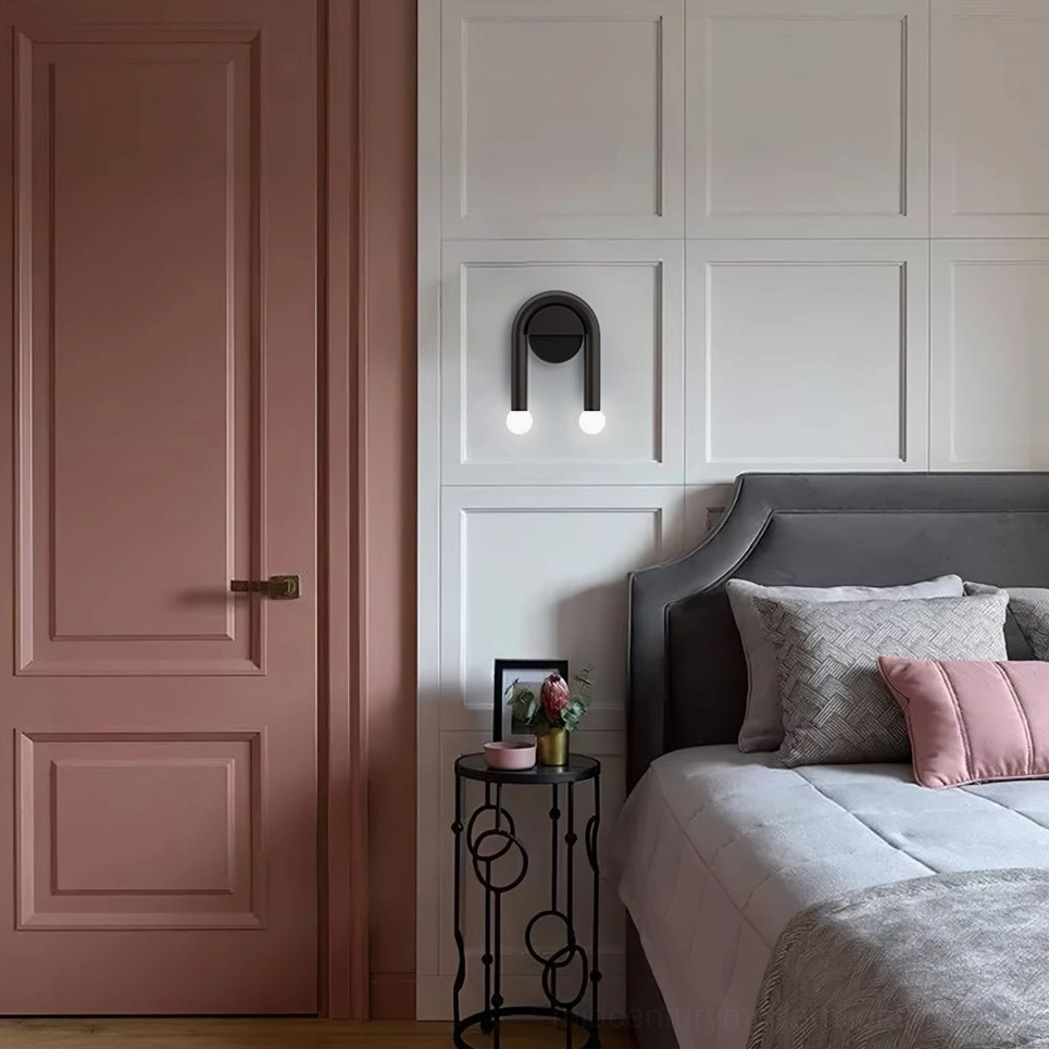 Black arched wall sconce at eye level beside bedside accent table in contemporary bedroom