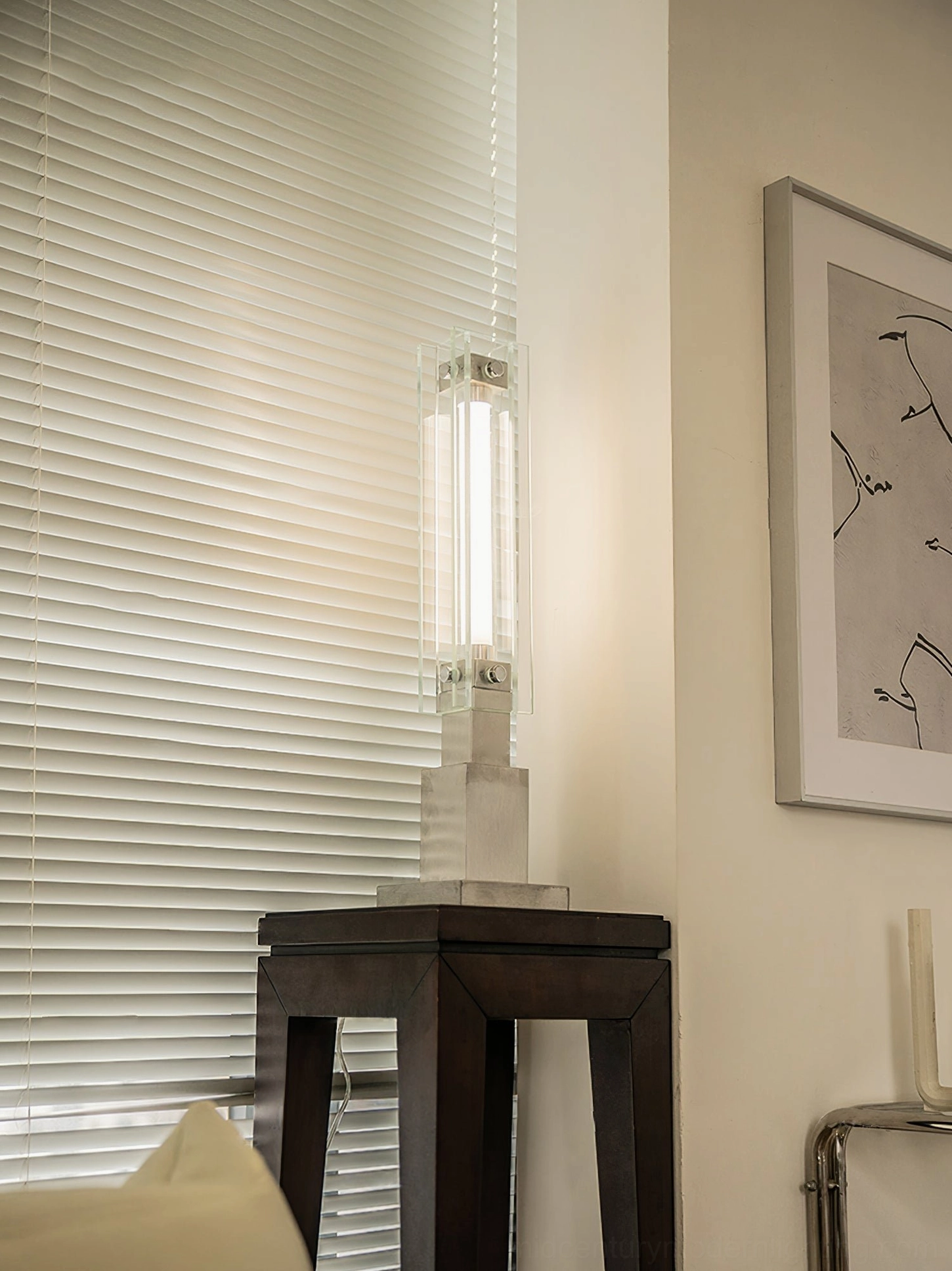 Elegant glass lamp casting warm ambient light on bedroom bedside table with curved furniture