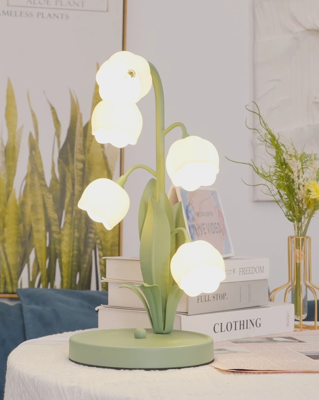 Bell Orchid Table Lamp sage green finish glowing on wooden furniture with botanical aesthetic