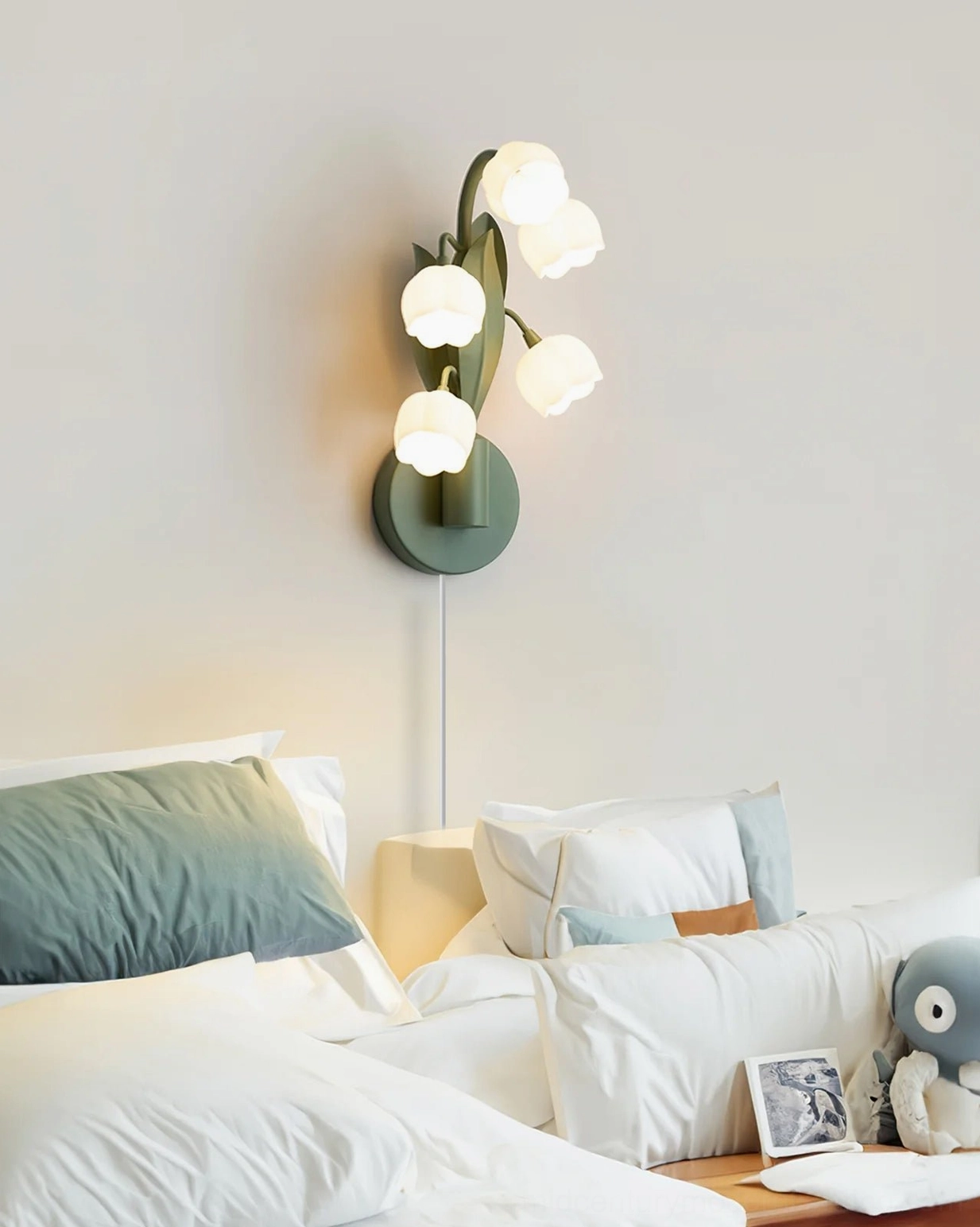 Bell Orchid plug-in lamp glowing in bedroom with bedding and decor, intimate lighting ambiance with four visible blooms