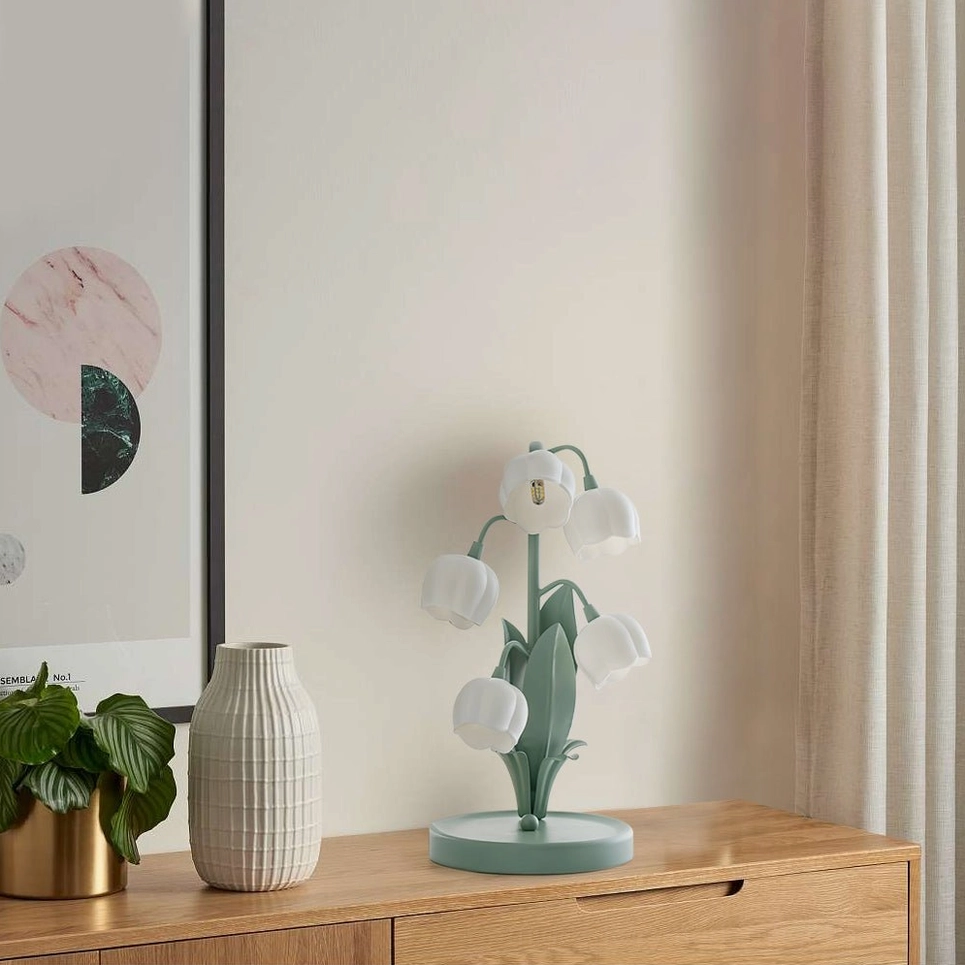 Bell Orchid Table Lamp in white finish casting gentle light on bedside table decorative display
