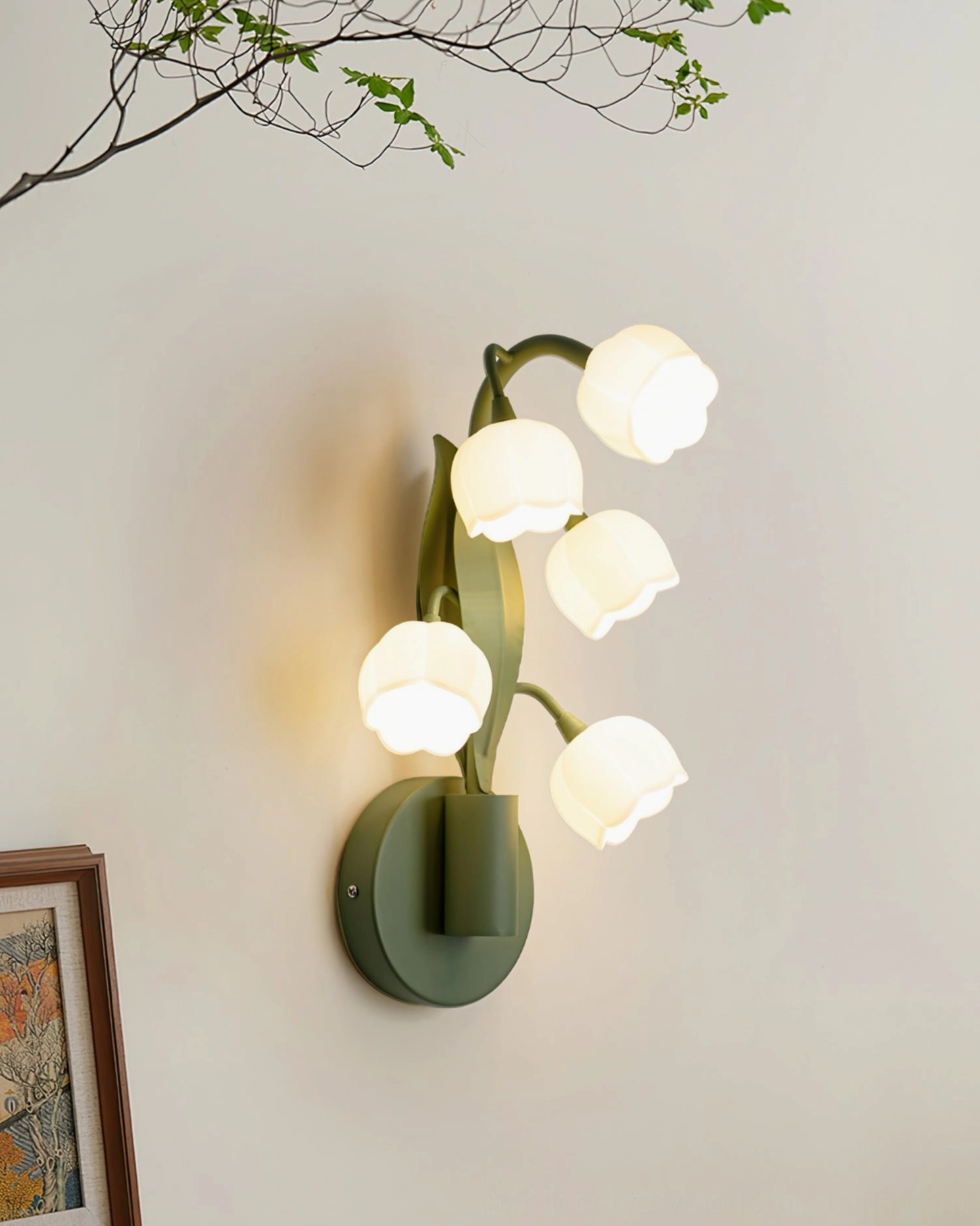 Bell Orchid wall lamp with five frosted bell flower shades displayed against wall art and decorative branches