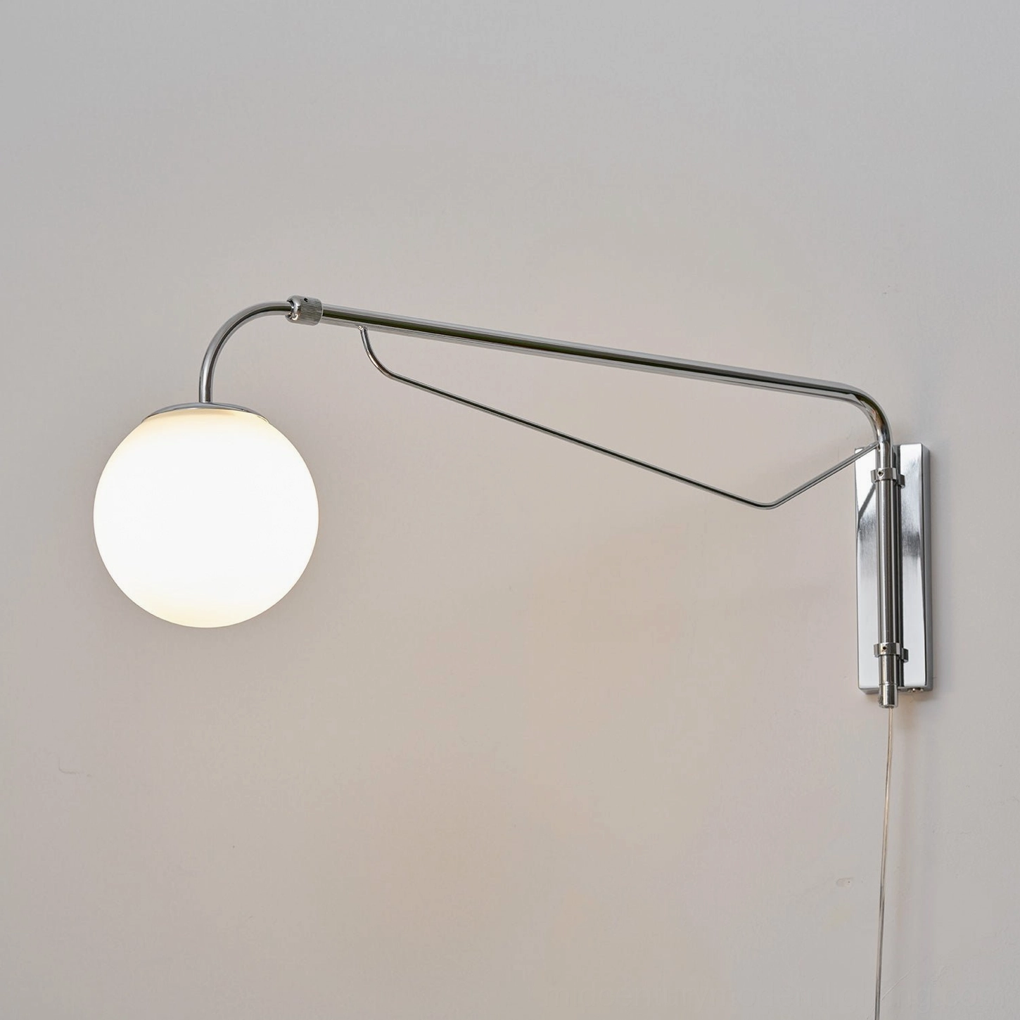 Rotatable wall sconce arm positioned for bedroom reading and task lighting