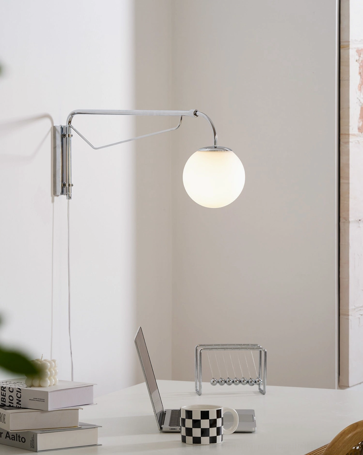 Polished chrome finish swing arm wall lamp reflecting light in modern interior
