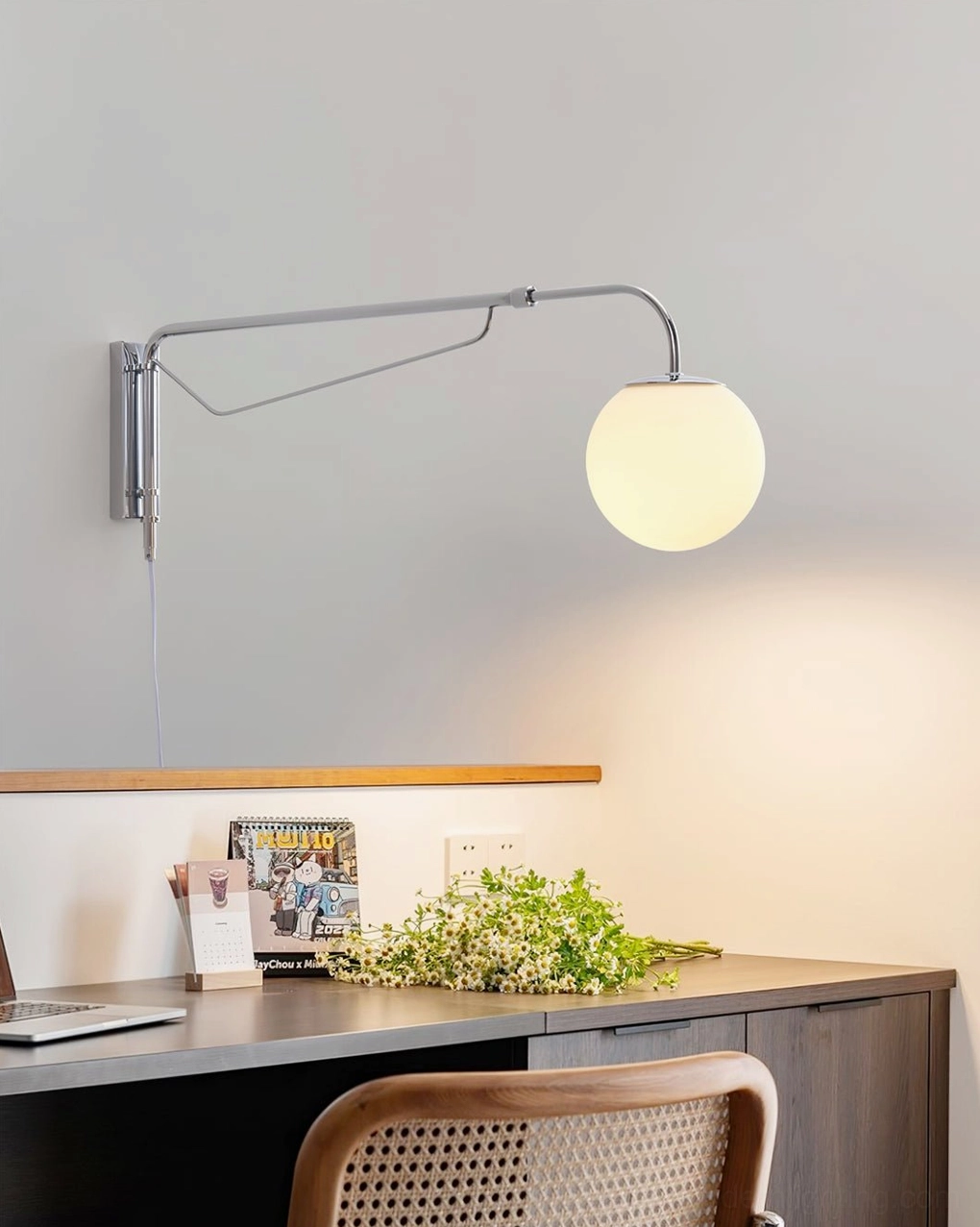 Matte white telescoping wall lamp above wooden desk in modern home office workspace