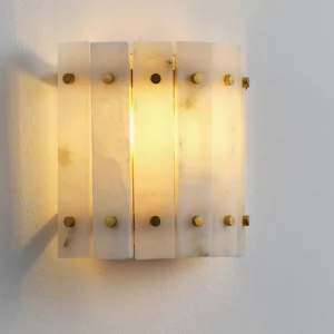 Lit Belmont Alabaster Wall Sconce close-up showing warm glowing translucent panels on white wall
