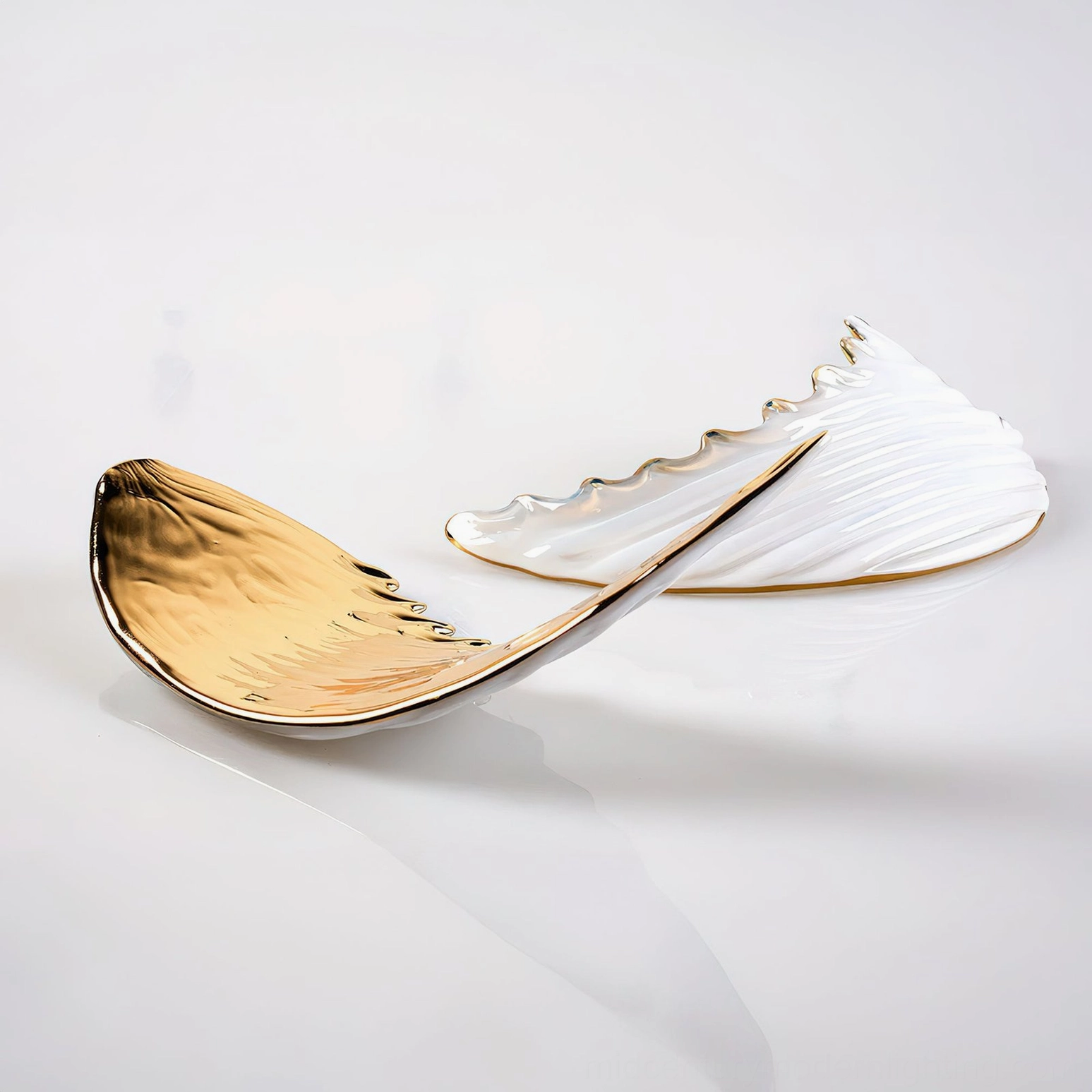Bennett Wings Chandelier individual wing parts studio view showing polished gold and white finish with detailed feather design on glossy reflective surface