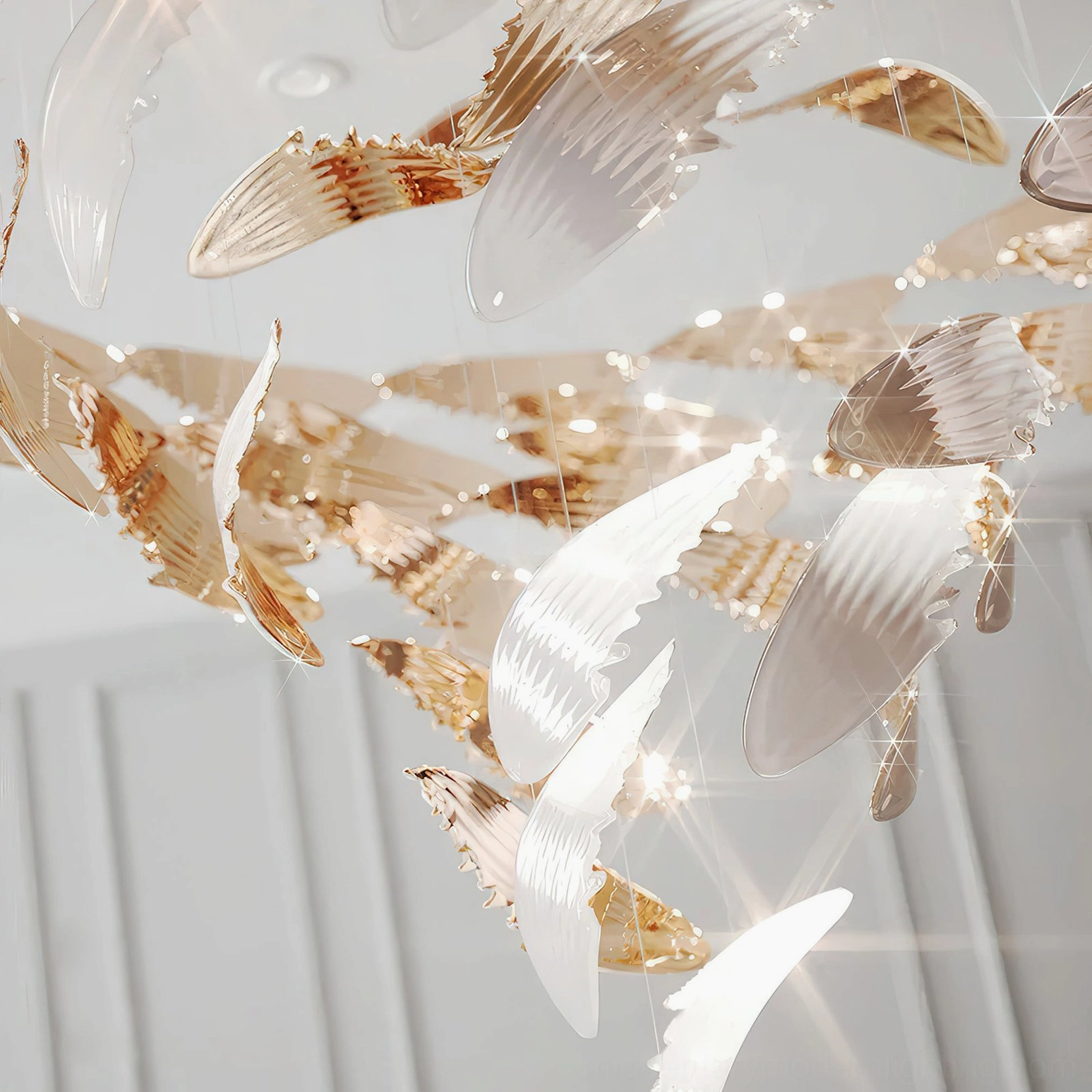 Bennett Wings Chandelier partial view of cascading wings in rose gold and white mixed finish with textured metal details on neutral panel backdrop