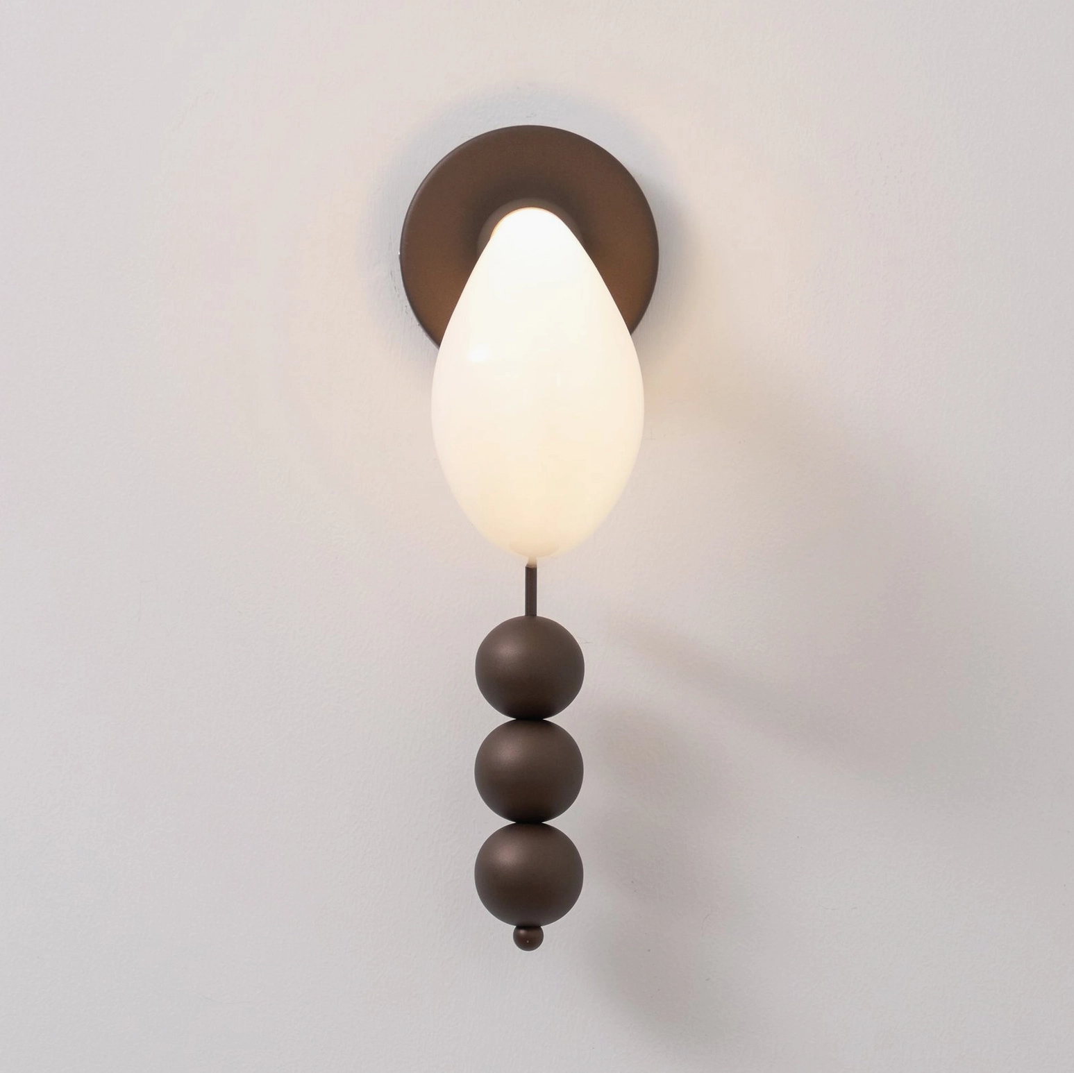 Bent glass wall sconce installation showing architectural impact and ambient lighting effect in contemporary home setting