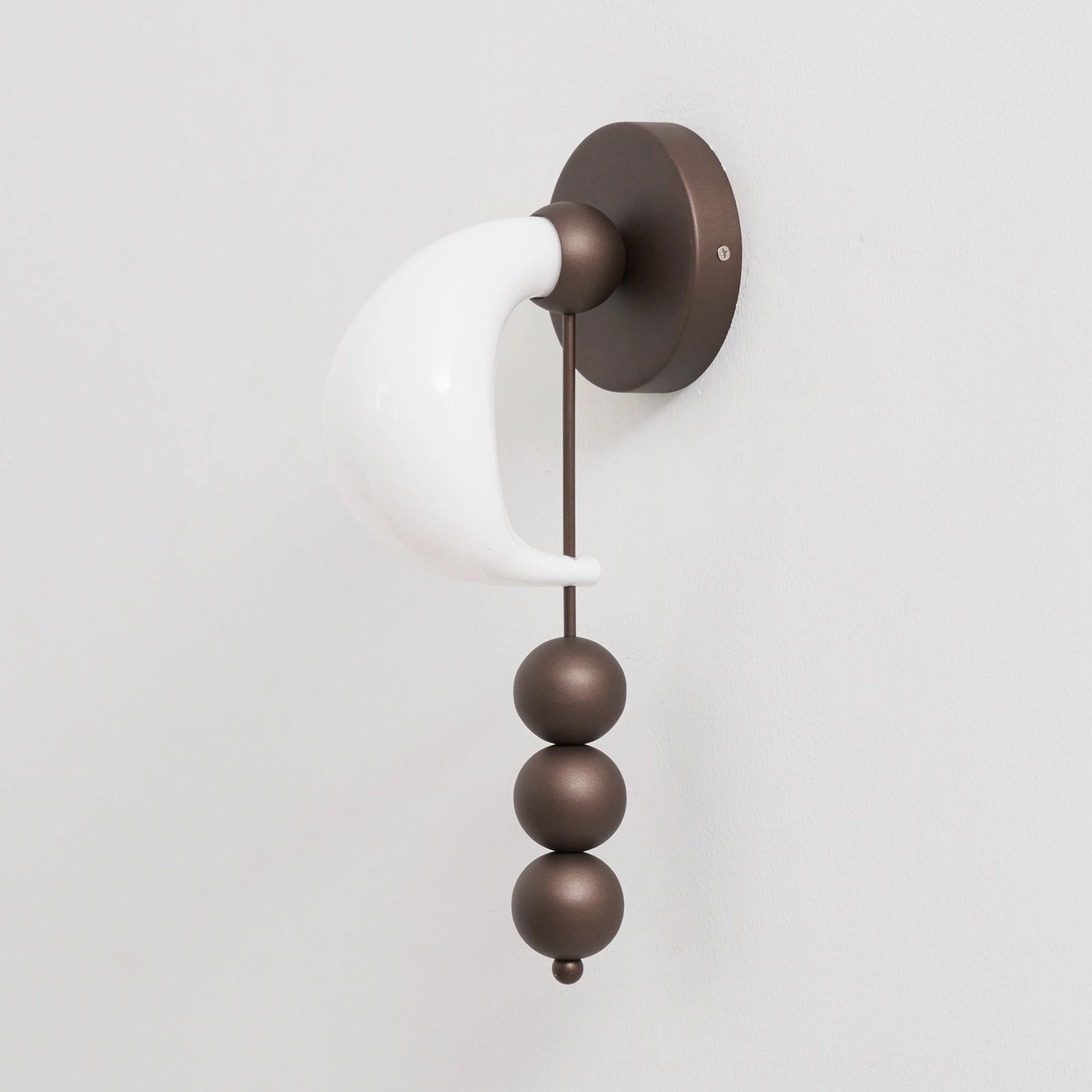 Bent glass wall sconce emphasizing handcrafted glass work and sculptural metal framework, designer lighting detail