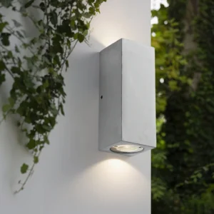 Bentu rectangular wall lamp outdoor entryway with warm downlighting against green foliage backdrop