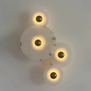 Beran alabaster wall lamp installed on residential interior wall, warm backlit ambient glow through translucent natural stone, modern minimalist sconce lighting