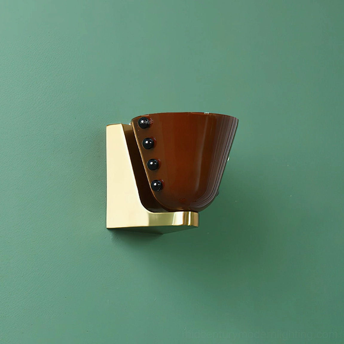 Berries wall lamp with dark brown glass shade, brass gold base plate, and black bead decorations on green wall background, low angle