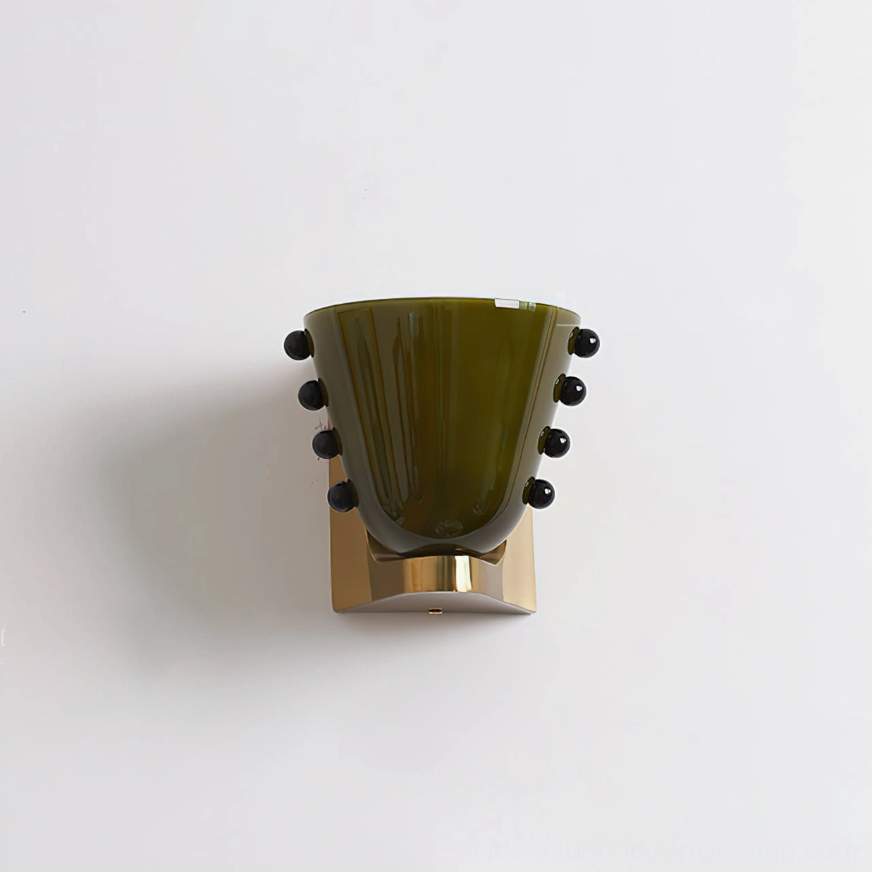 Berries wall sconce dark forest green glass shade with brass base plate and black bead decorative elements, low frontal angle