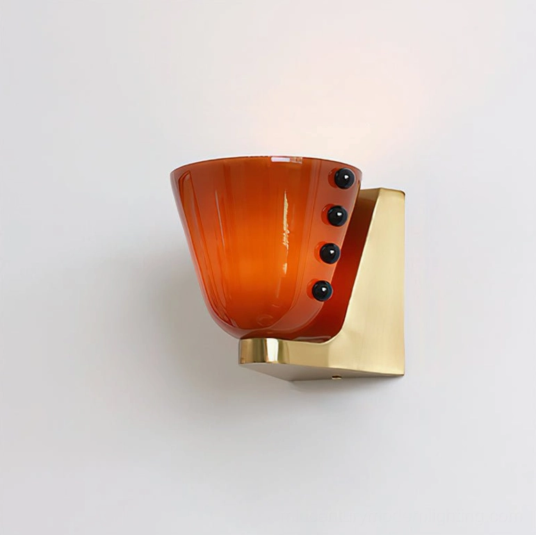 Berries wall lamp with coffee-colored glass shade and brass gold base components in neutral studio setting