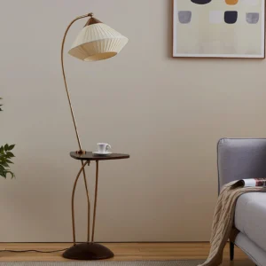 Bertil arc floor lamp in minimalist living room setting, brass gold arched frame with warm ambient lighting, modern interior design