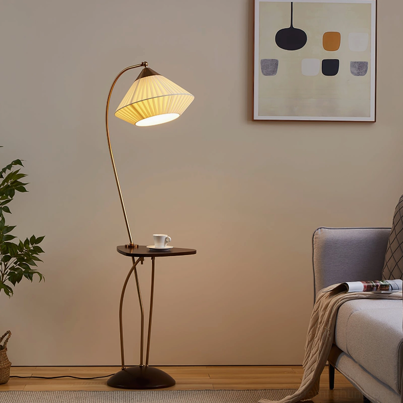 Lit Bertil arc floor lamp emitting warm soft ambient light, brass frame and beige pleated shade in warm interior setting