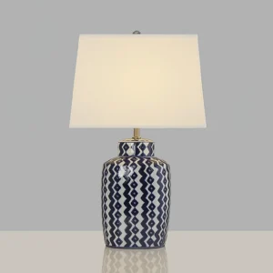 Beryl mid-century modern table lamp with polished metal accents and geometric patterned ceramic base on grey studio surface