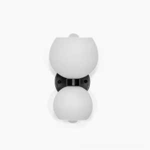 Betty sculptural brass wall sconce with frosted white glass globes, overhead studio view on clean background