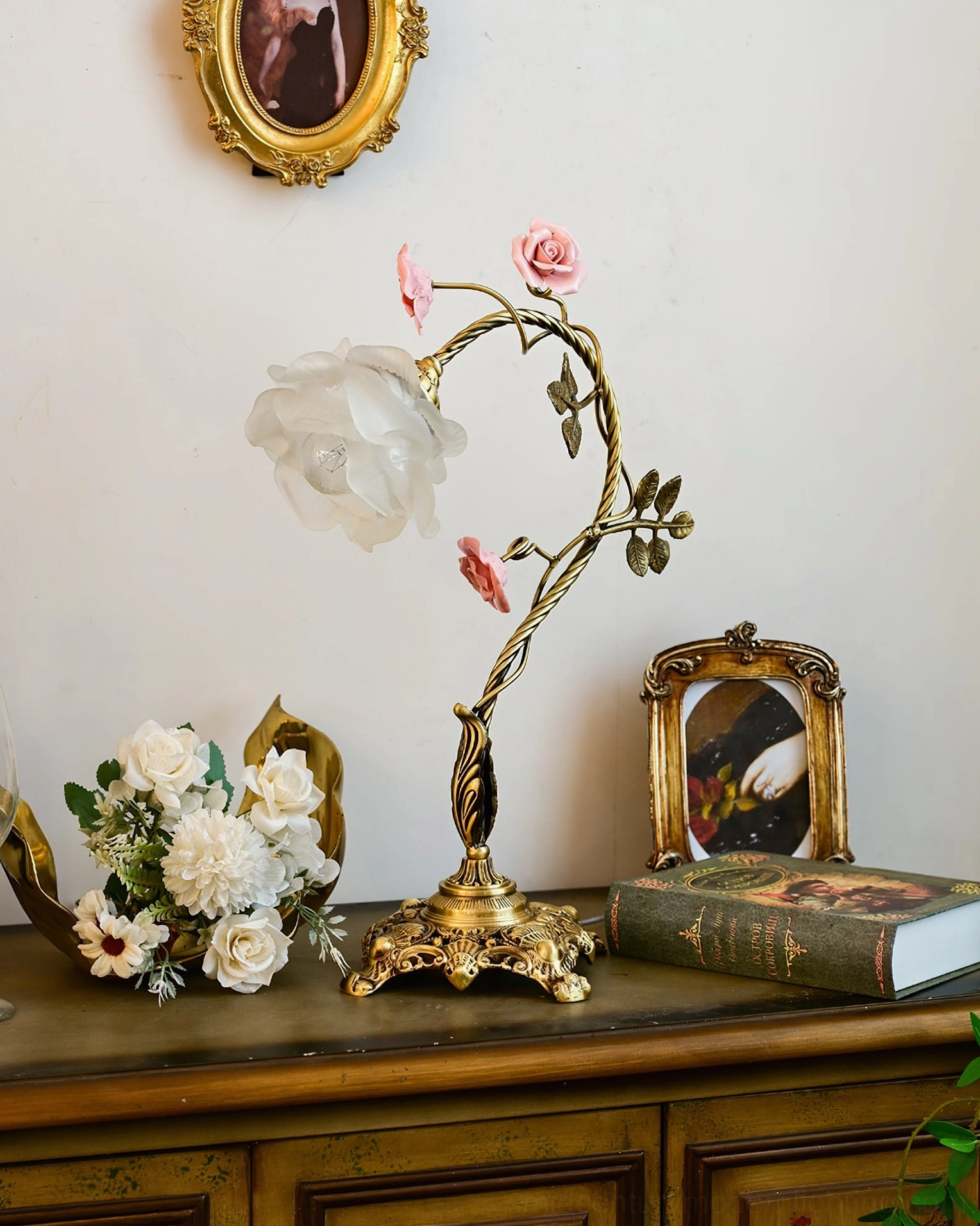 Unlit Beulah rose table lamp on vintage dresser counter with framed photo and floral bouquet styling