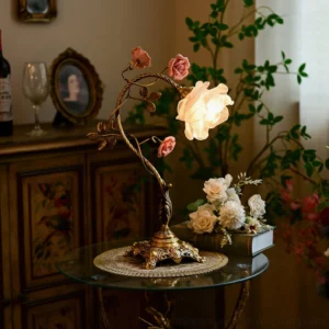 Illuminated Beulah botanical table lamp in vintage living room, three-quarter side view showing twisted gold stem and carved base