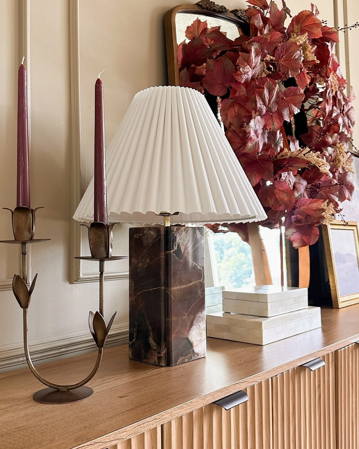 Bianca marble table lamp on entryway wooden console table with holiday wreath and brass sconces