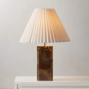 Bianca marble table lamp with brass fixtures displayed on white dresser, warm ambient lighting