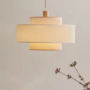 Close-up of Bianella layered pendant lamp showing linen pleated texture and warm neutral tones with dried floral styling
