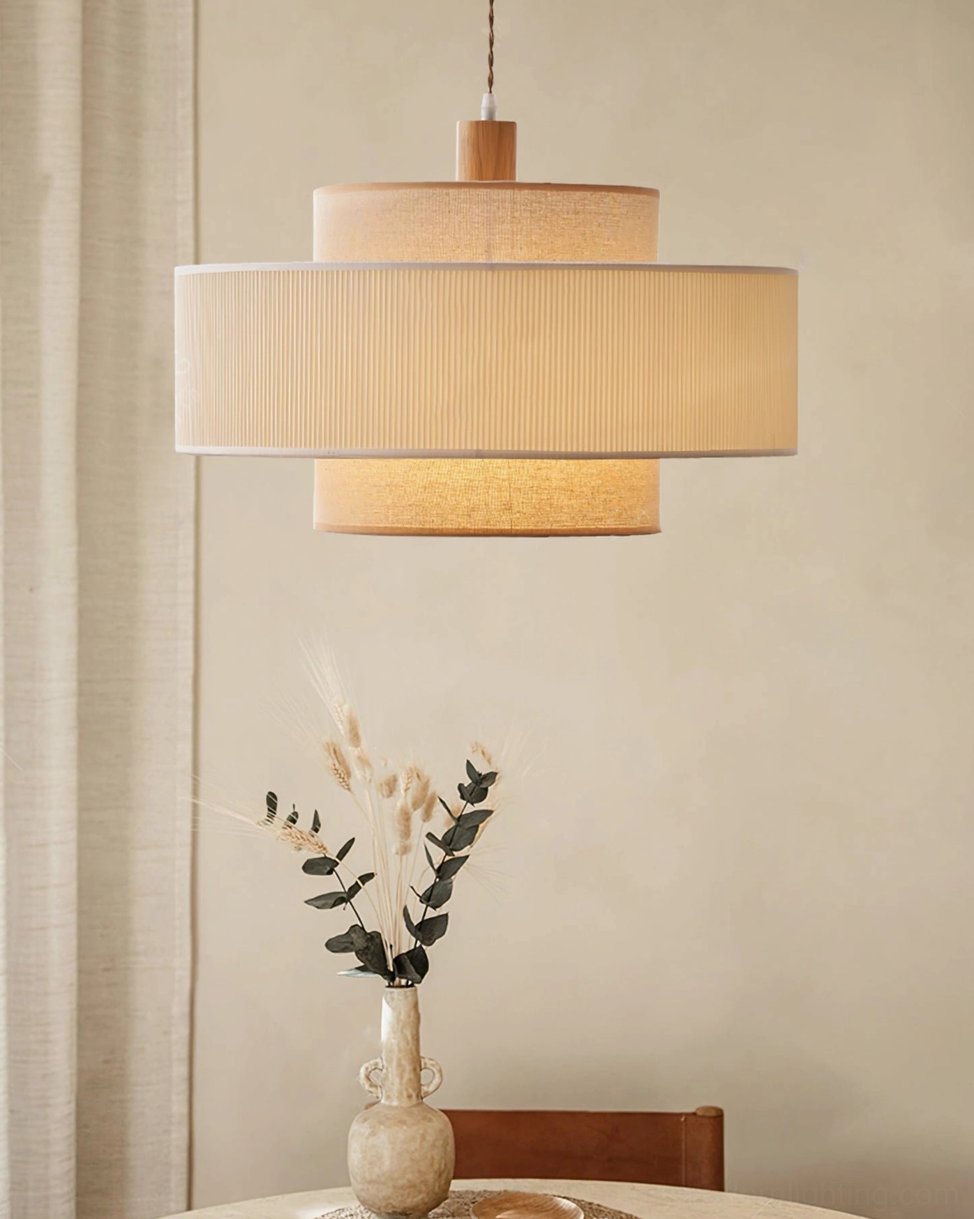 Bianella double-layer fabric pendant lamp above dining table setting with decorative vase, warm beige pleated shade