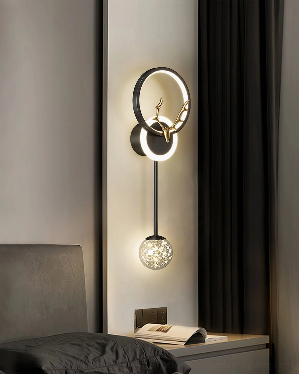 Black antler wall lamp on dark bedroom wall with warm ambient lighting and grey headboard