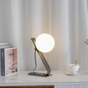 Black globe table lamp on modern home console table styled with coffee cup and decorative books