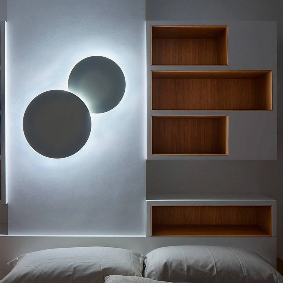 Matte black geometric disc wall sconce front view showing interlocking circular rings and modern mid-century aesthetic