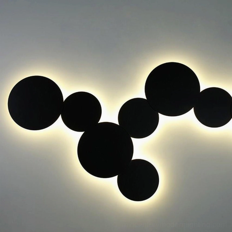 Matte black geometric disc wall sconce showing precision engineering and sculptural aesthetic for interior art lighting
