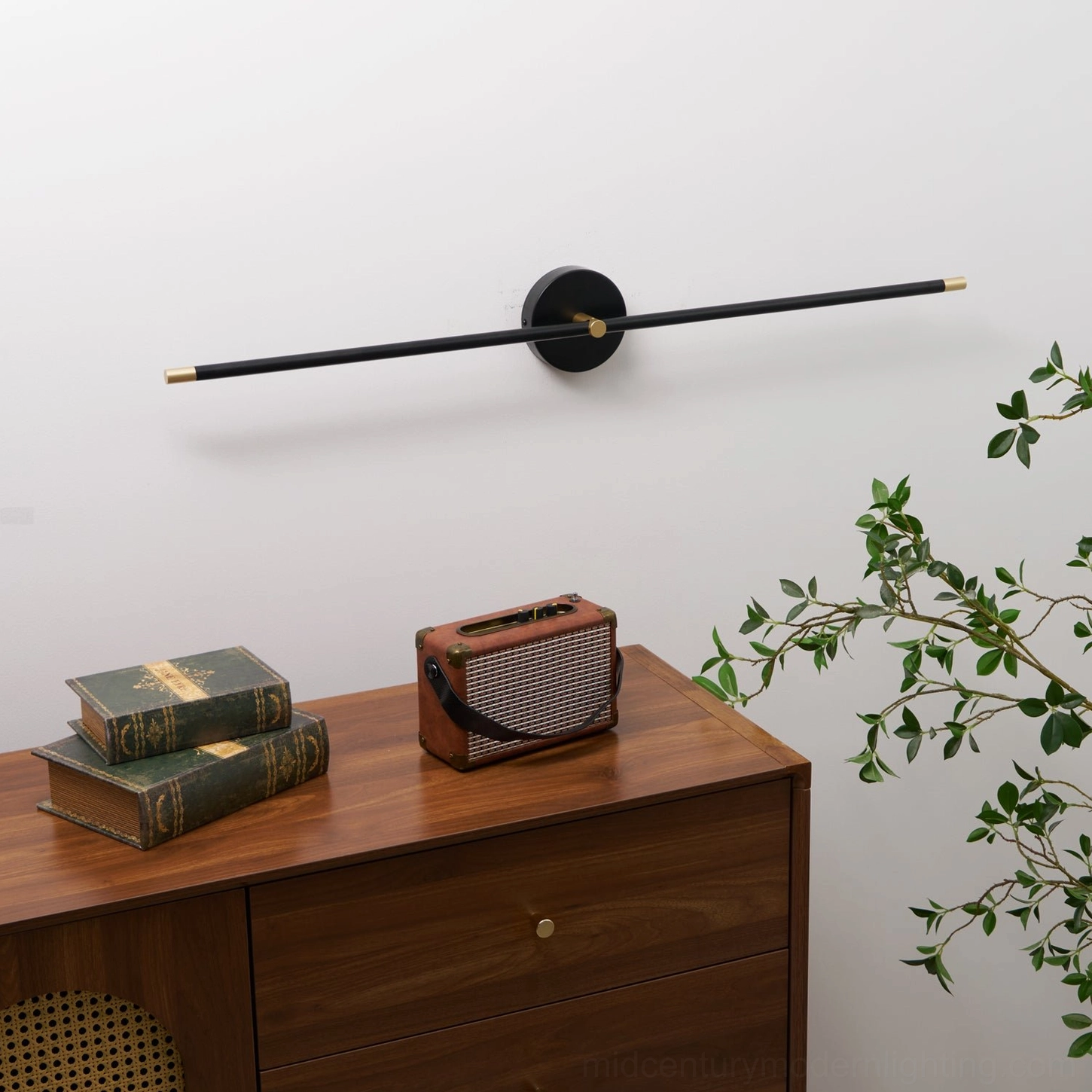 Matte black linear wall lamp with circular mounting plate detail