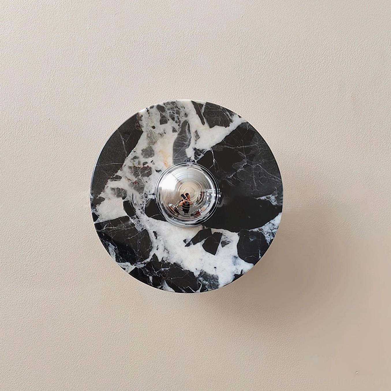 Medium diameter black and white marble wall lamp with chrome base fixture accent on interior wall