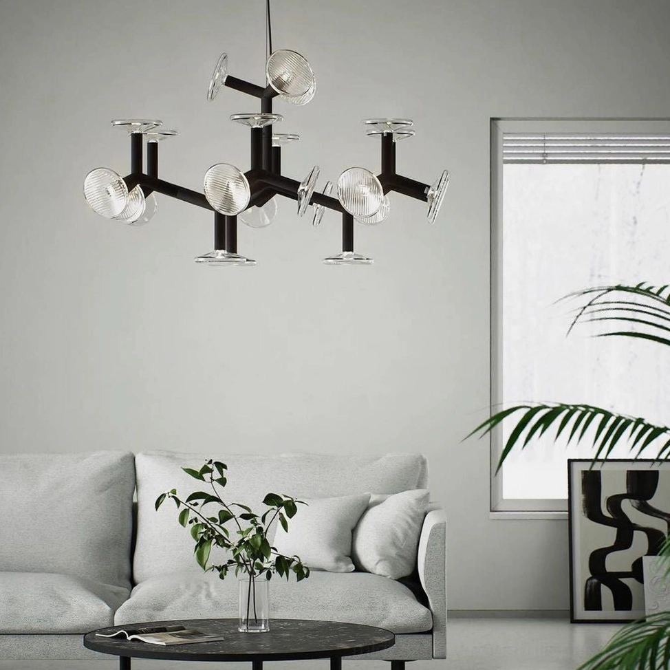 Black metal branch chandelier overhead view suspended above gray living room sofa