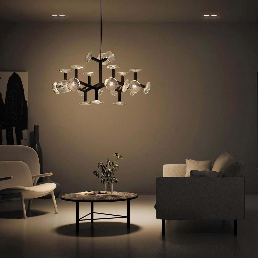 Black modern chandelier with warm ambient lighting in cozy dimmed living room setting