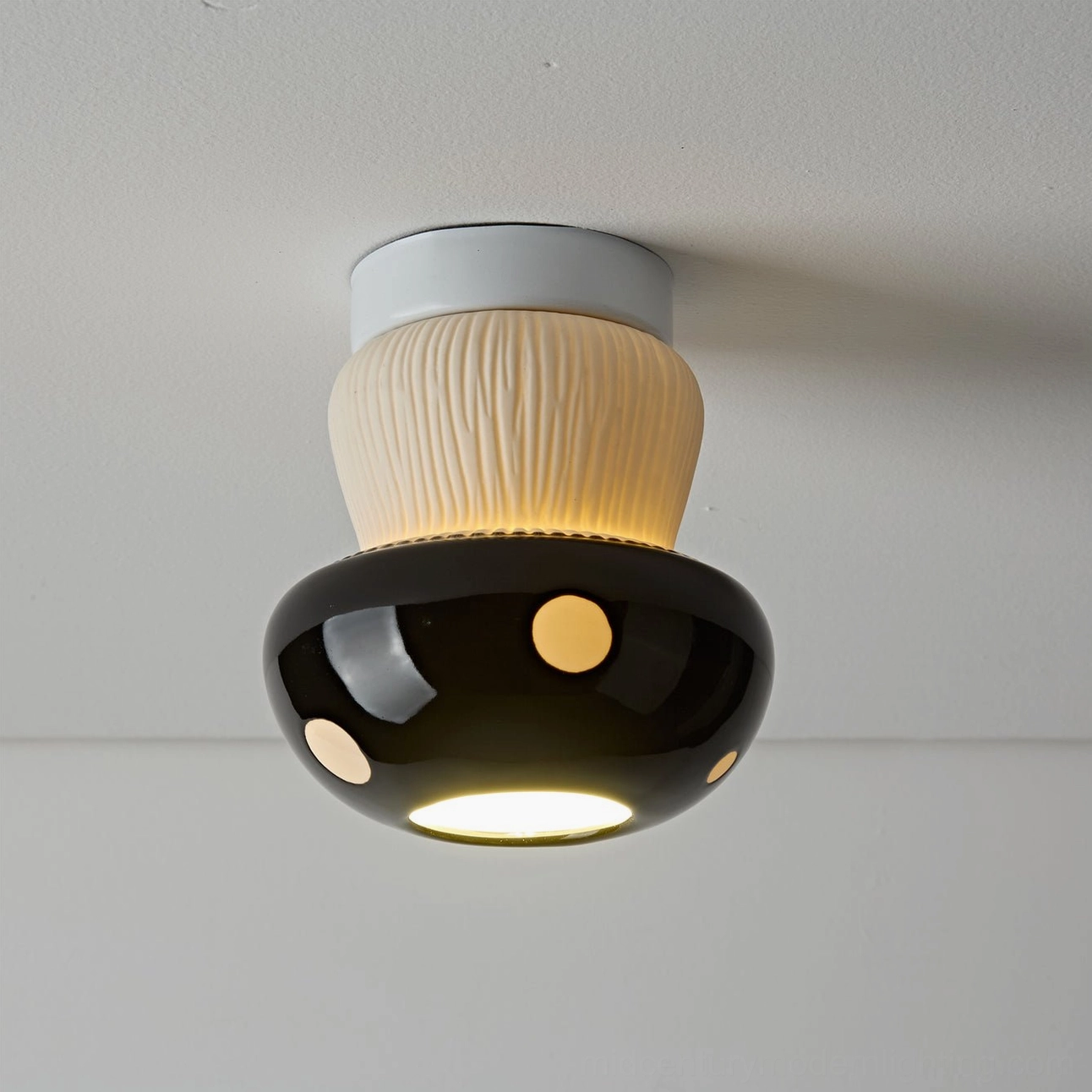 Overhead view of black mushroom ceiling fixture with two beige dots textured stem detail