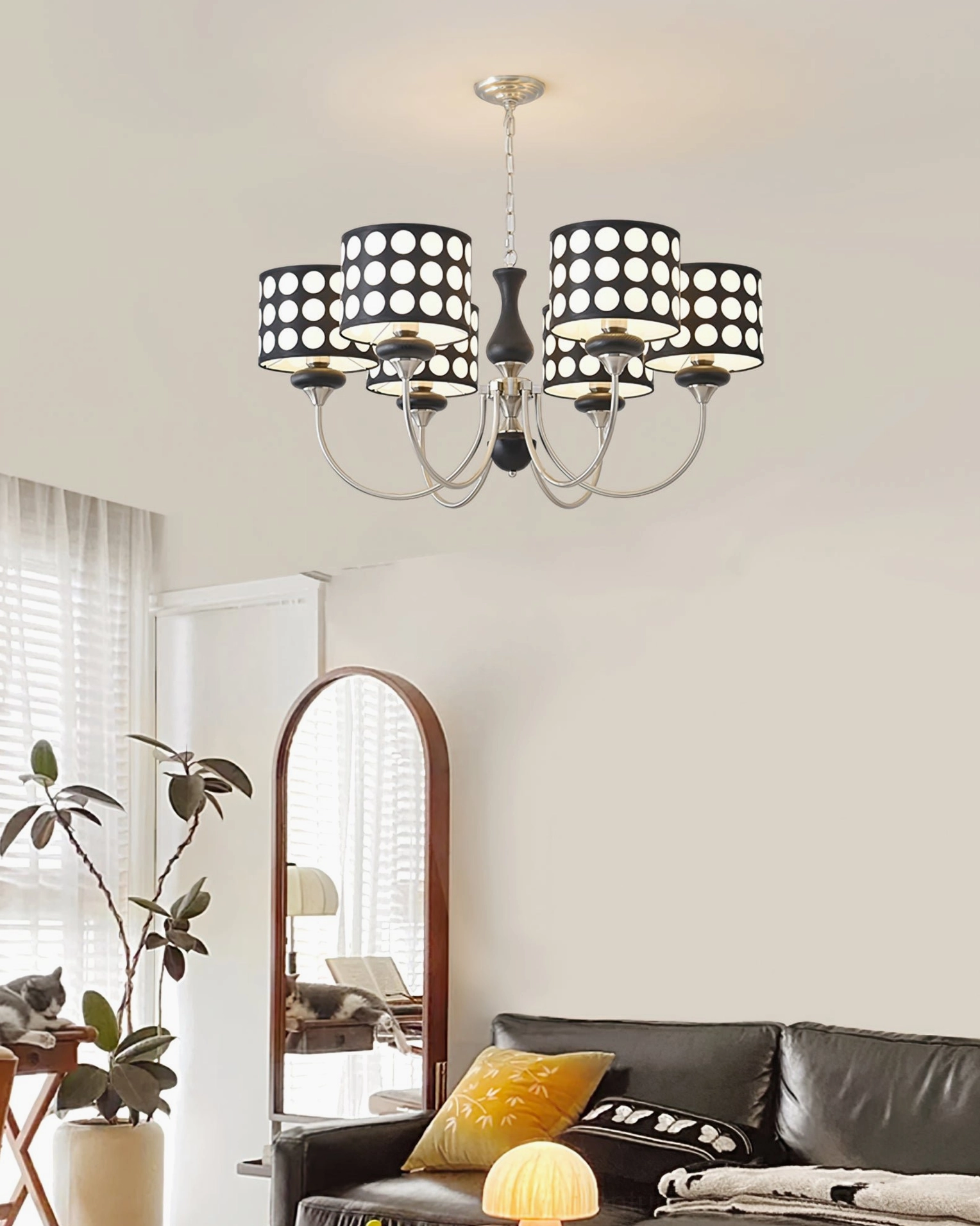 Large format black polka dot chandelier suspended in dramatic foyer setting with architectural ceiling