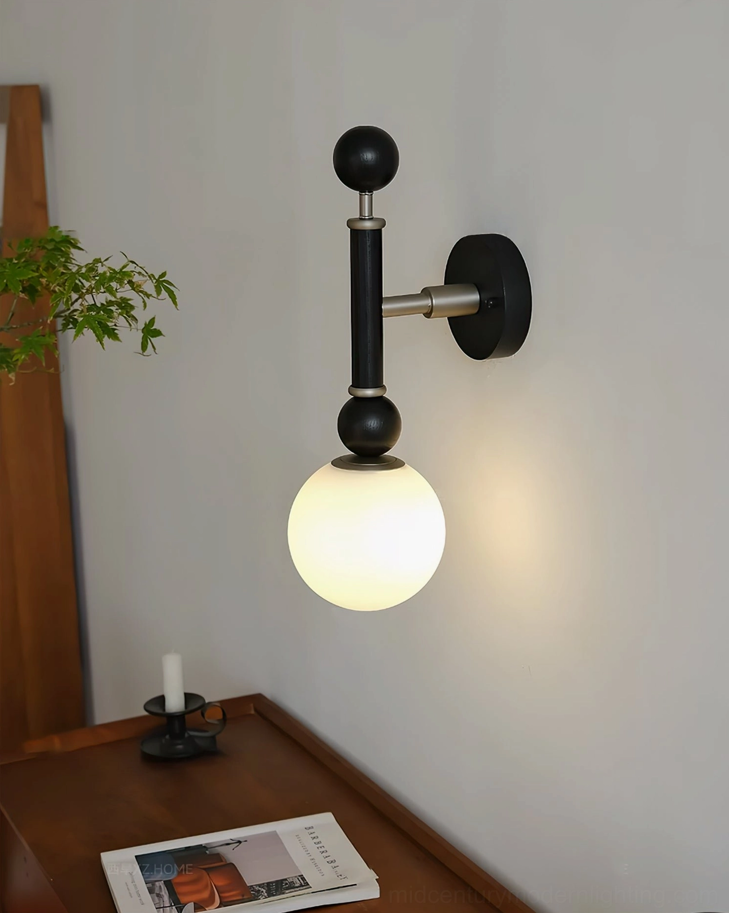 Sculptural globe wall sconce in black with sand nickel finish, dimensional product showcase