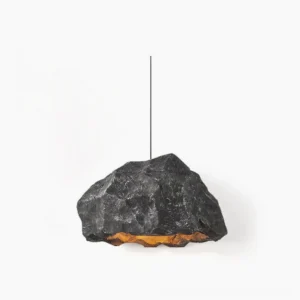 Kusa organic stone pendant light in matte black with warm bottom LED lighting against studio white background – sculptural mid-century modern ceiling fixture