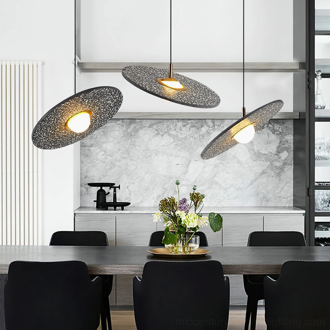 Multiple black terrazzo pendant lights hanging at staggered heights in modern kitchen dining area