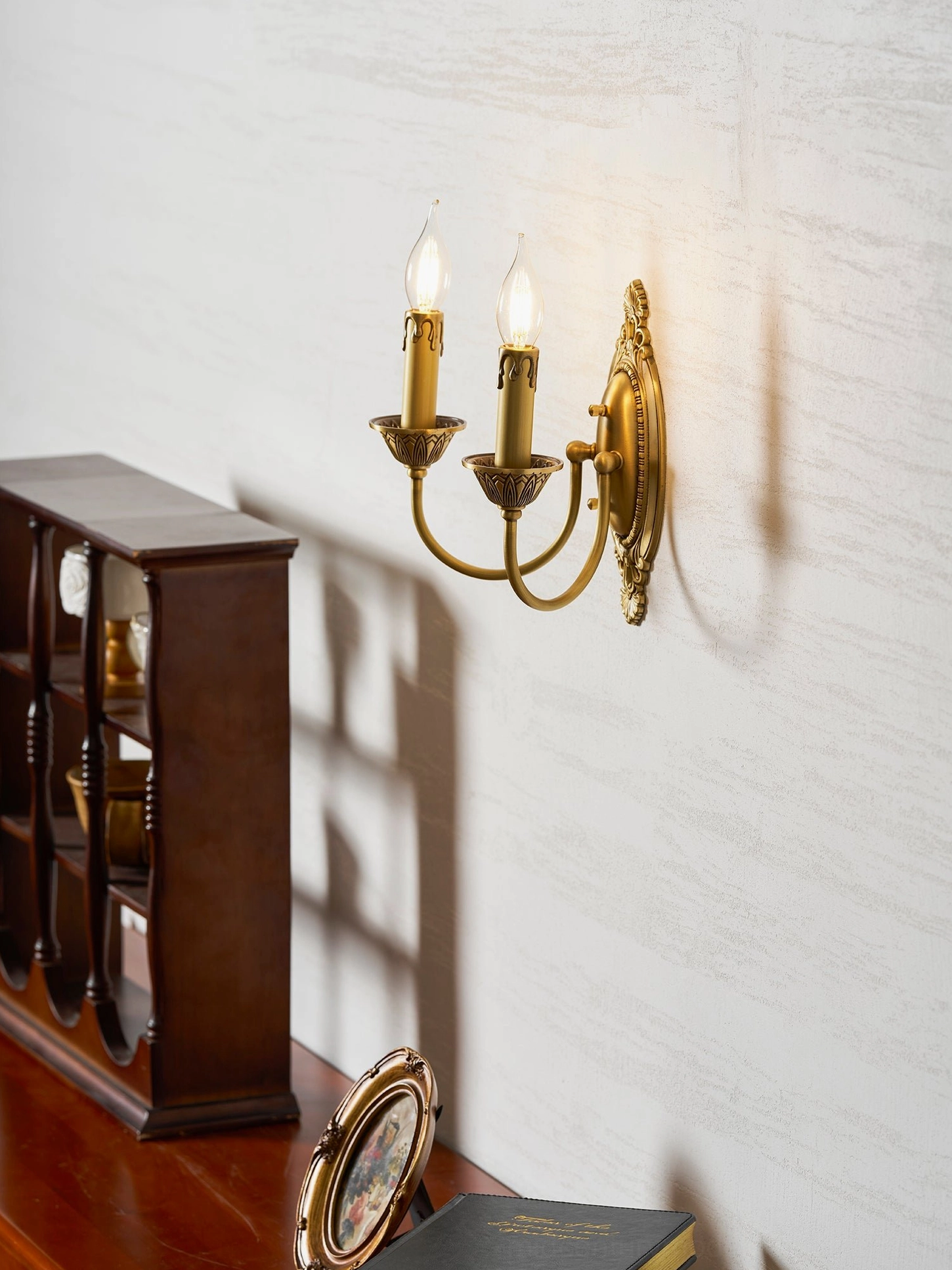 Blair brass candle wall sconce in hallway entrance creating welcoming warm brass lighting