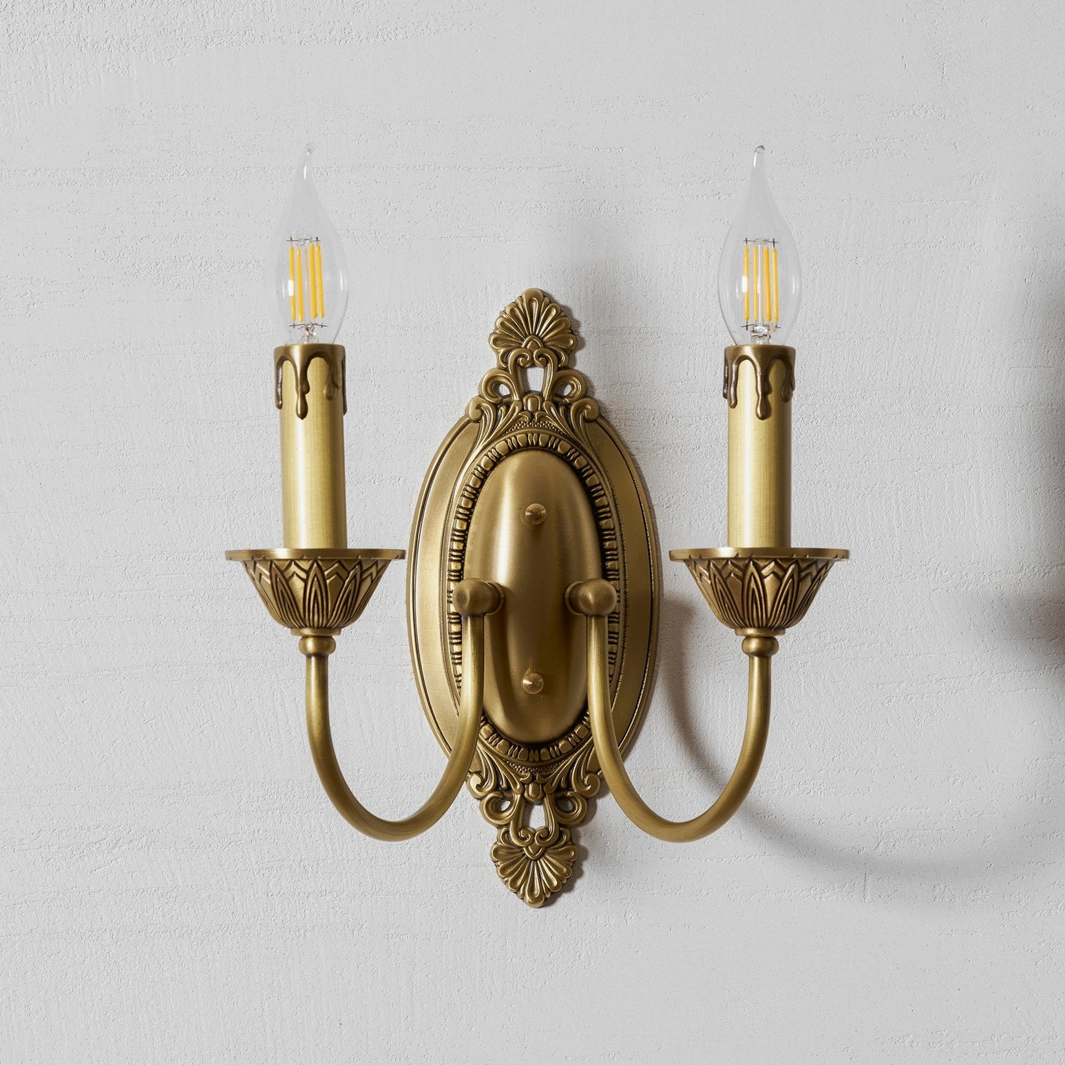 Compact Blair brass candle sconce in small bedroom creating intimate wall-mounted lighting